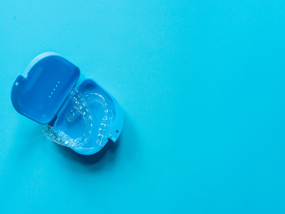 a set of clear aligners laying in a blue case