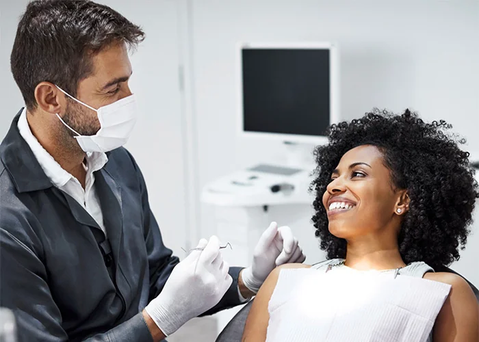 patient and dentist smiling and laughing during exam